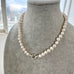 Pearl necklace on a mannequin bust with a blurred outdoor background