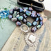 Vonk Jewellery peacock pearl and vintage silver watch fob necklace on 2 vintage postcards and with a vintage jewellery box