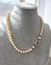 Pearl necklace on a gray mannequin bust with a blurred window background