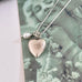 Vonk Jewellery vintage silver heart and pearl charm necklace on a vintage postcard