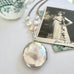 Vonk Jewellery c1880s Victorian buckle locket on pearl and silver chain and with a vintage postcard