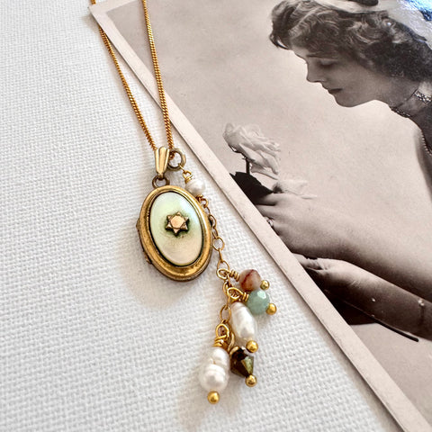 Vonk Jewellery rolled gold and mother of pearl locket and charm necklace with a vintage postcard of a woman holding a rose