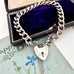 Vonk Jewellery curb link bracelet with heart padlock on a vintage jewellery box