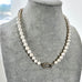 Pearl necklace on a gray mannequin bust with a blurred background