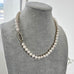 Pearl necklace on a gray mannequin bust with a blurred background