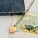 Back of WW2 ACMF heart-shaped pendant  sweetheart locket on a chain against an old letter background
