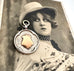 Vonk Jewellery antique 1926 silver watch fob with rose gold cartouche on a vintage postcard