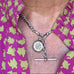 Antique watch chain and silver compass around a womans neck