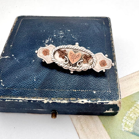 Antique Victorian silver and rose gold brooch on an old jewellery box