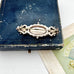 Back of antique Victorian silver and rose gold brooch on an old jewellery box