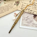Vonk Jewellery gold tone art deco propelling pencil necklace with pearl charms on vintage postcards