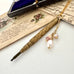 Vonk Jewellery gold tone art deco propelling pencil necklace with pearl charms on vintage postcards