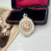 Vintage silver and rose gold pendant in an open velvet box with an old photograph underneath.