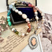 Vonk Jewellery 1933 watch fob multi pearl, crystal and gemstone necklace on a vintage jewellery box and vintage postcards 