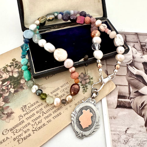 Vonk Jewellery 1933 watch fob multi pearl, crystal and gemstone necklace on a vintage jewellery box and vintage postcards 