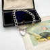 Silver chain bracelet with a heart charm on an open jewelry box