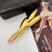 Vintage gold trifari brooch on a vintage postcard and with a vintage jewellery box in the background