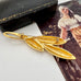 Vintage gold trifari brooch on a vintage postcard and with a vintage jewellery box in the background