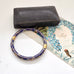 Vintage blue cloisonne bangle on an old jewellery box with a vintage Christmas postcard