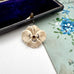 Vintage pansy brooch on a floral-patterned card