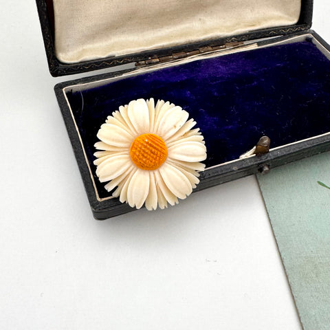 Vintage flower brooch in an open jewelry box on a white background