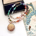 Multicolored beaded necklace with a vintage gilt locket on a vintage-style card