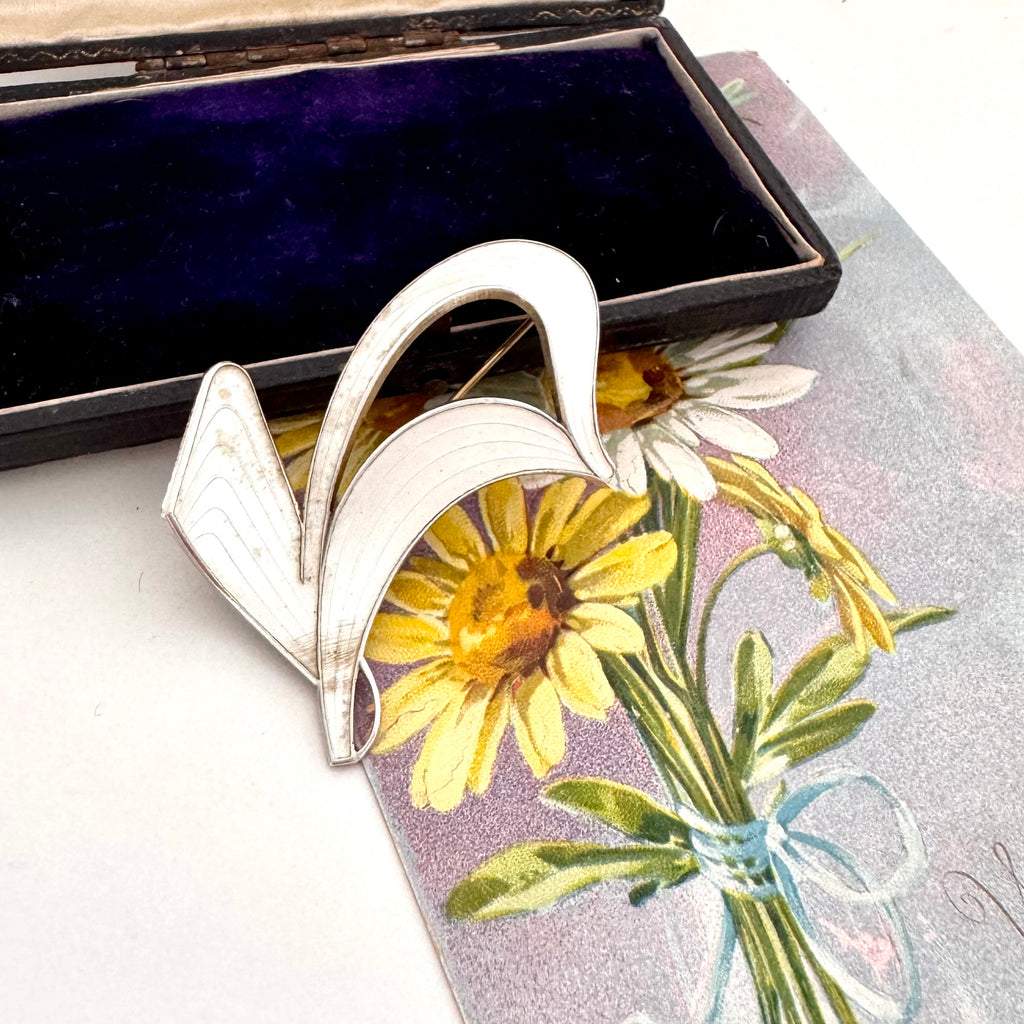 Silver Norwegian Ivar T Holth brooch on a floral card with an open jewelry box in the background