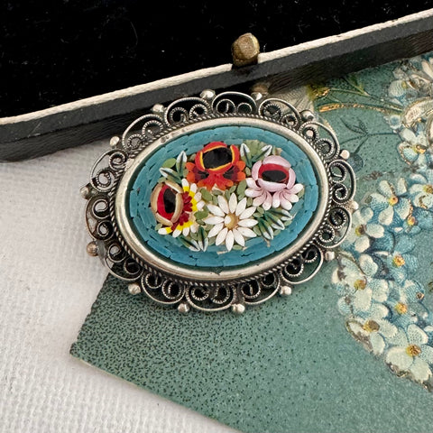 Vintage micro mosaic brooch on an old postcard
