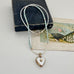 Pearl and larimar necklace with a vintage  heart-shaped mother of pearl and gold locket on an old box and fan illustration