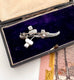 Silver brooch with rhinestones in a black box on a snowy landscape card