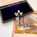 Silver brooch with rhinestones in a black box on a snowy landscape card