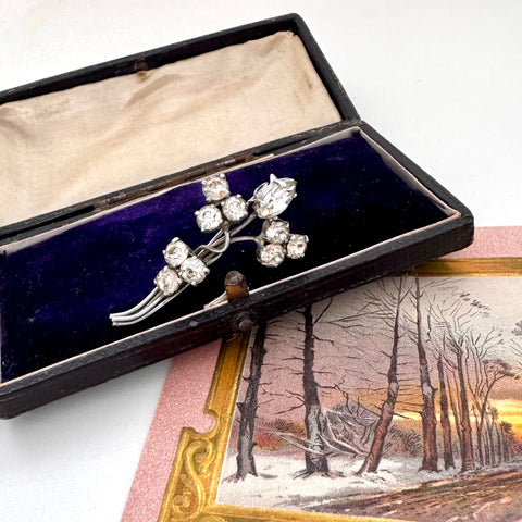 Silver brooch with rhinestones in a black box on a snowy landscape card