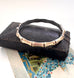 Vintage rolled gold on sterling silver bamboo-style bracelet on a black leather surface with a floral card underneath.