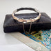 Vintage rolled gold on sterling silver bamboo-style bracelet on a black leather surface with a floral card underneath.