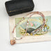 Peruvian opal and pearl necklace with heart locket on a vintage-style card with fan and bottle illustration
