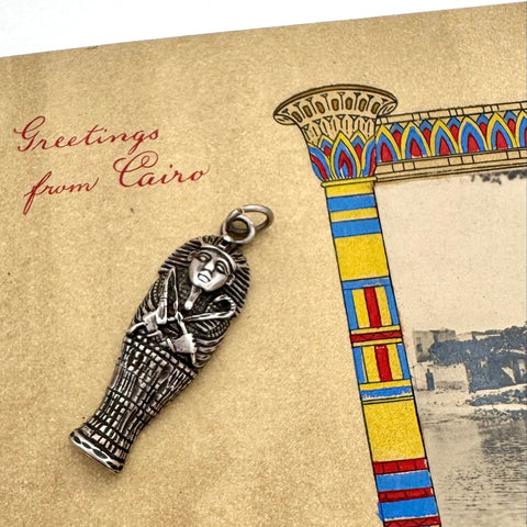 Silver sarcophagus charm on a 'Greetings from Cairo' themed card with an Egyptian column design.