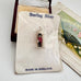 Sterling silver pendant of a guard in a tower, mounted on a white display card labeled 'Sterling Silver' and 'MADE IN ENGLAND', with its original box and a vintage fan in the background.