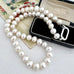 A  pearl necklace with a silver clasp, displayed on a vintage floral card and a black jewelry box.